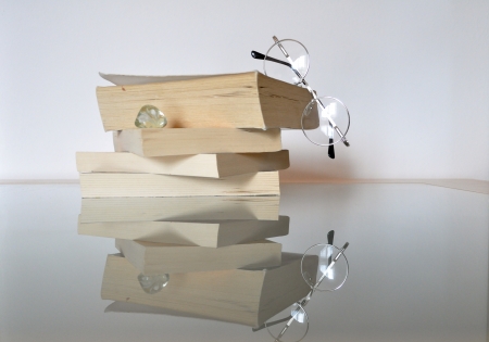 stack of books on a glass table with glassesの写真素材