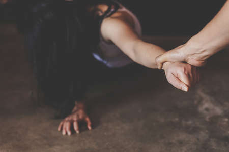 Man's hand holding a woman hand for rape and sexual abuse.Domestic Violence, human trafficking...