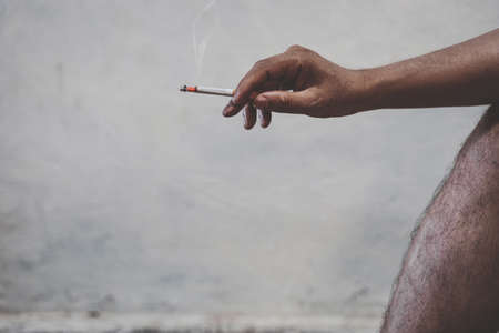 Close up man hand with burning cigaretteの写真素材