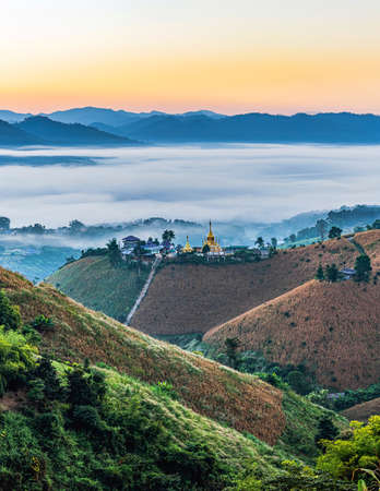 Morning mountain with village  stupa in the mist.の写真素材