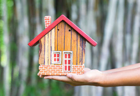 Hands holding house, Real estate investment is a business to build a house to sell to buyers in the...