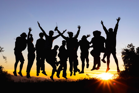 Group many peoples silhouettes jumping in sunset on mountain, Happy new years concept,の写真素材