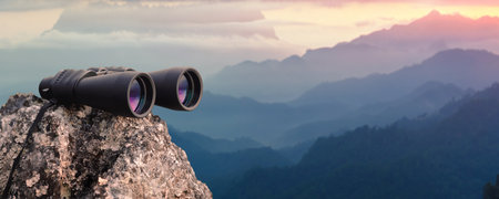 Binocular on top of rock mountain at sunsetの写真素材