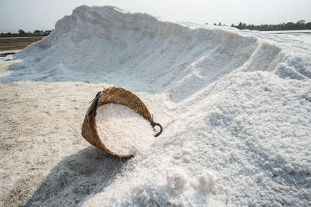 Salt in basket with background of salt pile