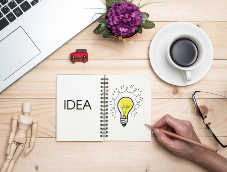 Top view(flat lay) Cup of coffee with notebook on wooden desk.Relaxing time after workの写真素材