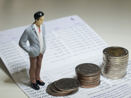 Money, Financial, Business Growth concept, Miniature figure of businessman standing on the stack of coins .の写真素材