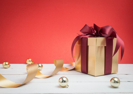 Valentine festival , New year Gold gift box with red ribbon. Red background for create idea copy space.の写真素材