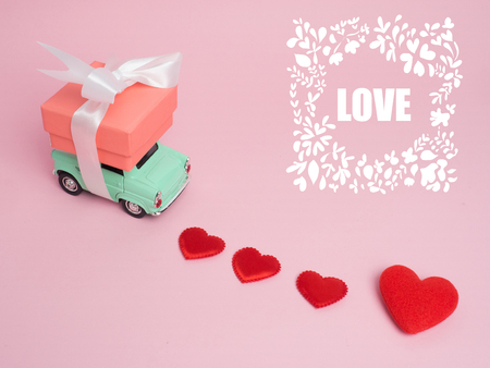 Vintage car carry a  gift box on color background and top wood table for Christmas and The New Year and Valentine's day .Decoration love heart .の写真素材