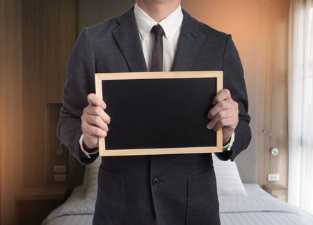 Young man giving hand on black background.Hands open businessman. Piggy bank are here.Saving money concept.の写真素材