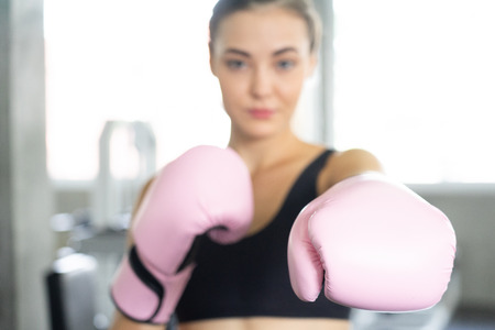 Boxing young beautiful woman exercises with pink glovw.She  doing exercise and punching .の写真素材