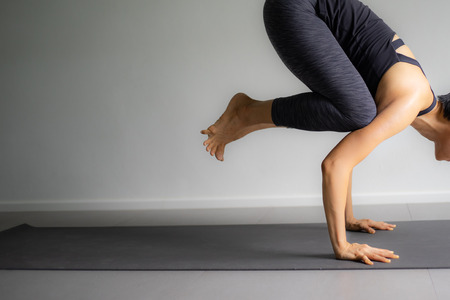 Young woman practicing yoga in  gray background.Young people do yoga indoor.