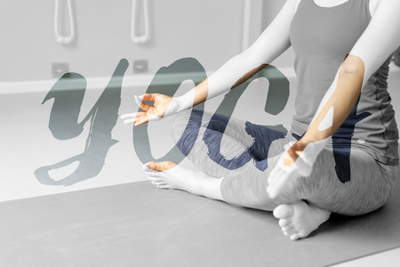 Young woman practising yoga in grey background.の写真素材