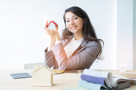 architecture, building, construction, real estate and property concept - close up of hands holding house  model.Home loan property ownership assurance conceptの写真素材