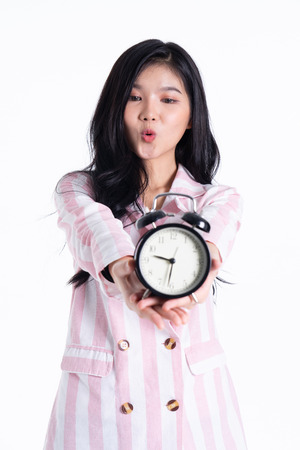 attractive young  asian business  woman thinking  about time isolated on white background.woman hold clock and happy.の写真素材