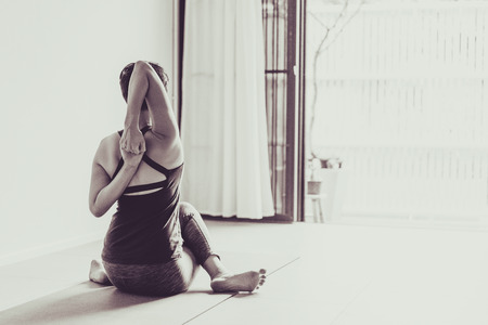 Asian young woman practicing yoga in  gray background.Young people do yoga indoor.
