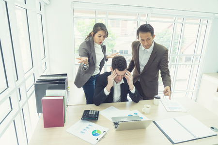 business, teamwork, people and crisis concept. business team sitting  solving problem in office. businessmen and women serious argument negative emotion .のeditorial素材