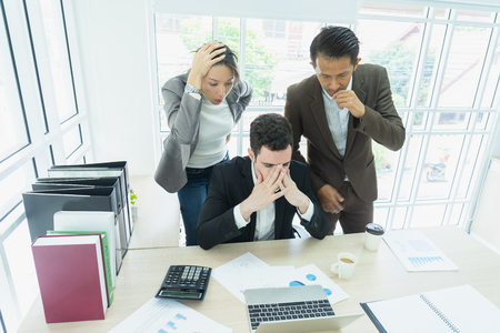 business, teamwork, people and crisis concept. business team sitting  solving problem in office. businessmen and women serious argument negative emotion .のeditorial素材