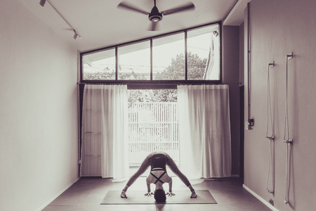 Asian young woman practicing yoga in  gray background.Young people do yoga indoor.の写真素材