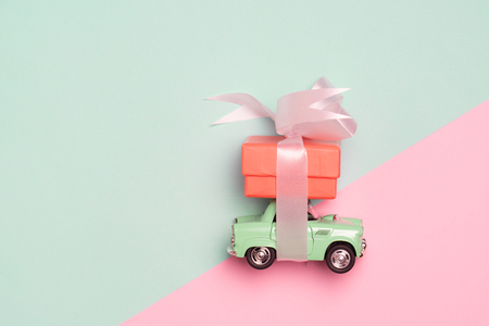 Vintage car carry a  gift box on color background and top wood table for Christmas and The New Year and Valentine's day .Decoration love heart .の写真素材