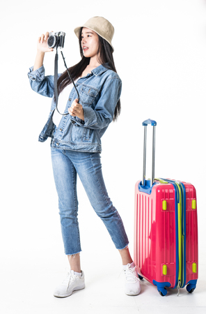 Beautiful young woman smiling and pulling pink color luggage isolated on white background.Asian woman going to summer vacation.Travel trip funny.の写真素材