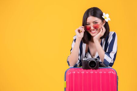 Tourist woman in summer casual clothes.Asian Smiling woman .Passenger traveling abroad to travel on yellow background.Asian woman going to summer vacation.Travel trip funny.の写真素材