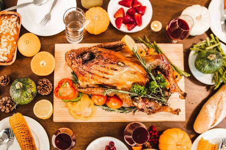 Roasted  chicken or turkey with sauce and grilled autumn vegetables: corn,pumpkin  on wooden table, top view, frame. Christmas or Thanksgiving Day food concept.の写真素材