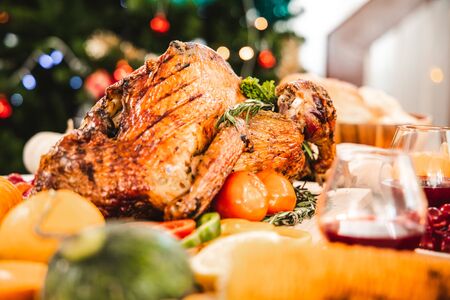 Roasted  chicken or turkey with sauce and grilled autumn vegetables: corn pumpkin  on wooden table, top view, frame. Christmas or Thanksgiving Day food concept.の写真素材