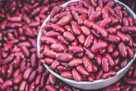 Close-Up View Of Red Beans Scattered Beans Around On A Cup With Beans Background. (View From Above)の写真素材