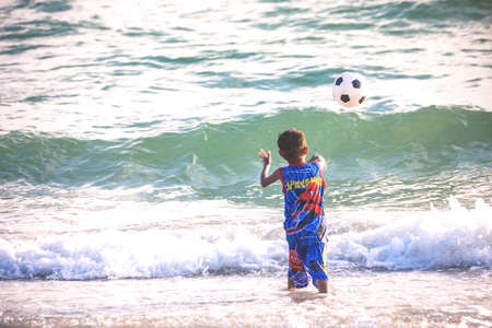 Koh Sichang, Chonburi, Thailand - April 18, 2016: Image View Of Children Playing Football On Seashore With Wave Background.のeditorial素材