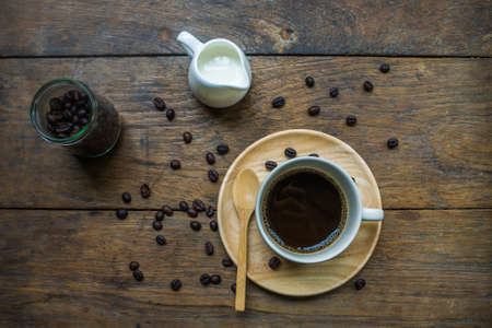 Cup Of Espresso And Roasted Coffee Beans Scattered On Wooden Background.の写真素材