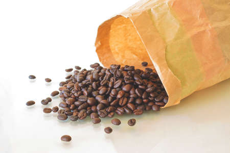 Roasted Coffee Beans With Paperbag Scattered Isolated On White Background.