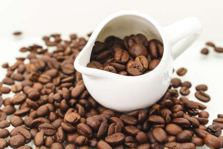 Roasted Coffee Beans In Cup Scattered Isolated On White.の写真素材