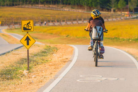 Image Rear Of Biker With Helmet Cycling In The Park.