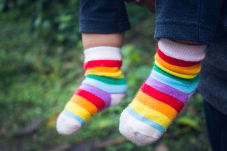Kid Feet Wearing Colorful Socks In The Winter Season.の写真素材