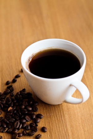 Aromatic fresh coffee in porcelain cup on wooden tableの写真素材