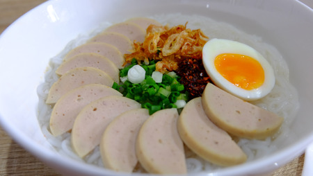 Vietnamese noodle soup decorated with preserved pork sausage, spring onion, chilli paste fried onion and boiled eggの写真素材