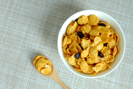 Corn flakes in white bowl on texture backgroundの写真素材