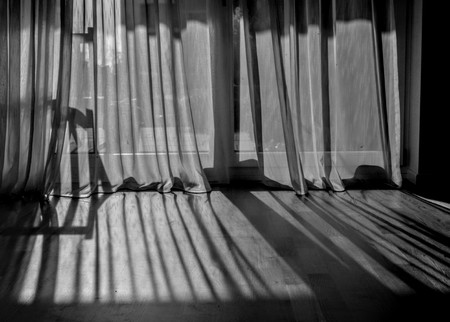Curtain shadow on the wooden floor in a strong afternoon lightsの写真素材
