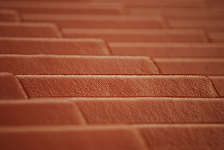 Monotonous pattern of brown tiles on a roof of a house. Parallel lines and repetitive pattern..の写真素材