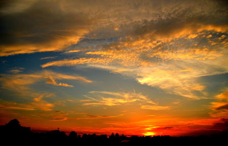 Sunset with a mixture of many colors, like black orange blue whiteの写真素材