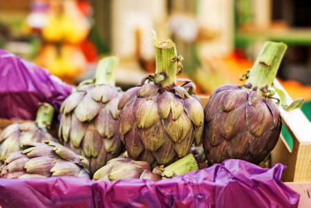 Fresh green purple artichokes in a boxの写真素材