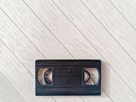 Video cassette on a light wooden background