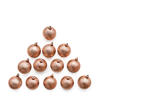 Golden christmas balls arranged in a triangle on a white background. Greeting card, template or...