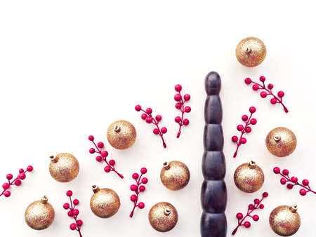 Dildo, golden Christmas balls and small twigs with red berries. Christmas or New Year Festive...