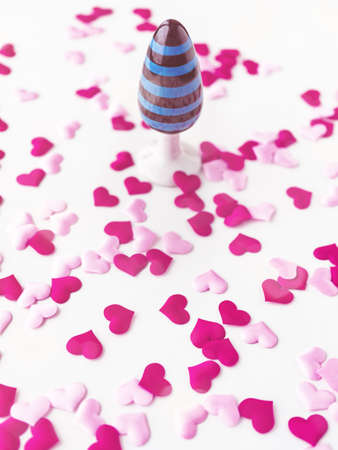 Ceramic toy with a pattern in blue and black stripes is on a white background with red and pink...