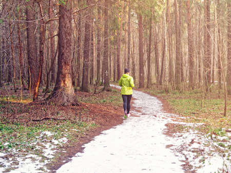 A girl in a green jacket, black sports pants and pink sneakers. Image on the theme of a healthy lifestyle, strengthening immunity, maintaining the physical formの写真素材