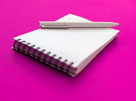 A notebook with white sheets in a cage and a penの写真素材