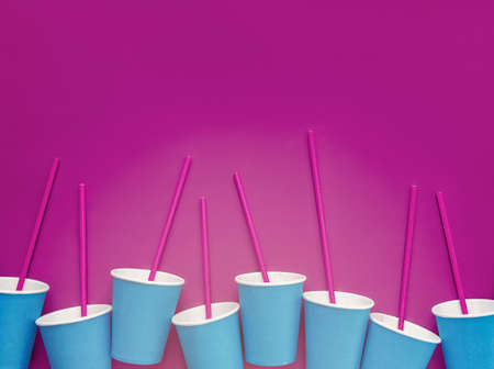 Empty paper blue cups and tubes await the beginning of the party, event, celebration. Artistic enhancement of purple color and noise. Background for banners, cards, blog, advertisingの写真素材