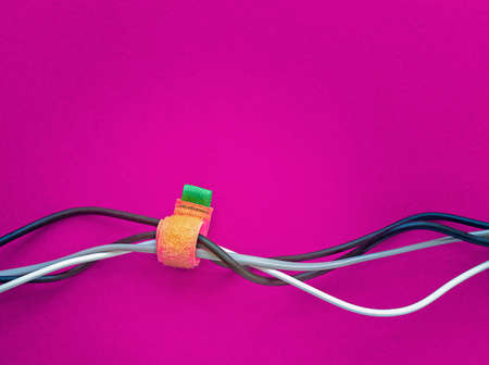 Wires for various purposes and colors are on a purple background. Fastening cables with Velcro tape....