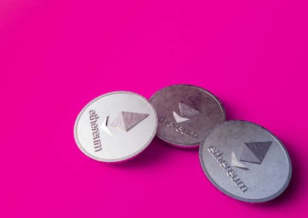 Three coins of the Ethereum crypto currency are on a purple background. 3D renderingの写真素材
